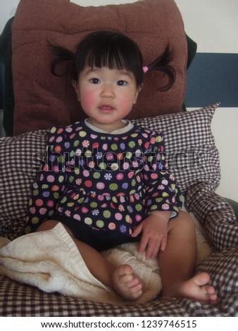 Asian little girl sit in the chair indoor