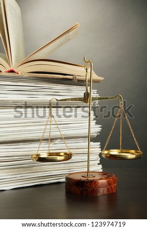 Gold scales of justice and folders on grey background