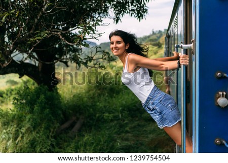 The girl travels by train to beautiful places. Beautiful girl traveling by train among mountains. Travel by train. Travelling to Asia. Trains Sri Lanka. Railway transport. Railway. Transport Asia Royalty-Free Stock Photo #1239754504