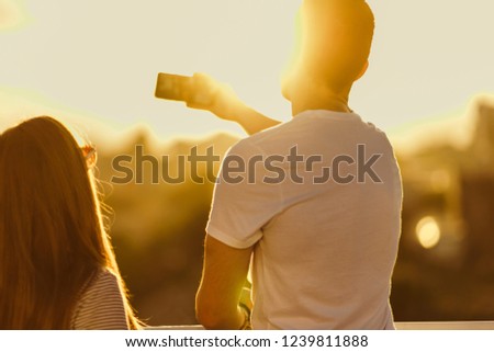 Romantic couple doing selfie with cellphone on sunset