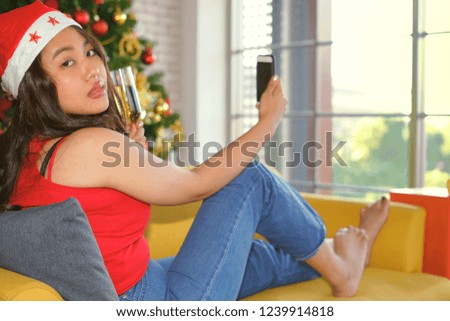 Asian girl taking pictures in the mobile phone to send boyfriend at Christmas.