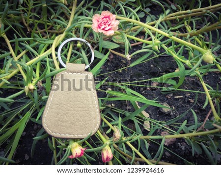 Brown leather key chain on flower background