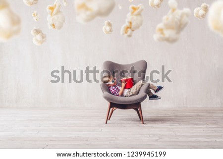 Sleeping little boy with popcorn in the cinema