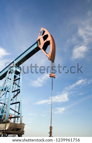 Oil and gas industry. Work of oil pump jack on a oil field. Blue sky