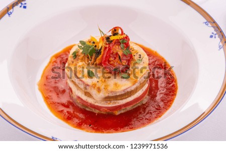 A cheese lasagna with meat under tomato sauce with dried tomatoes