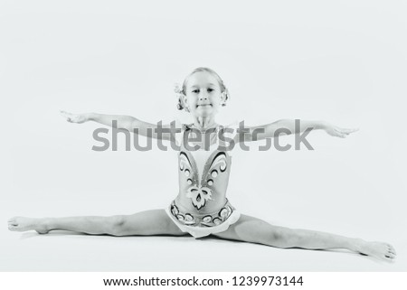 a girl sits on a string in a bathing suit, a string, on a white background, pigtails, a swimsuit with accessories, gymnastics, acrobatics, a baby is flexible, black and white photo