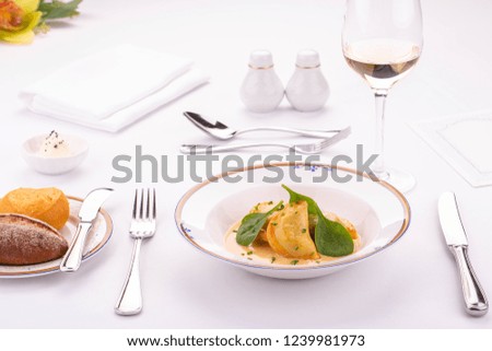 Fried meat dumplings in cheese sauce with greens
