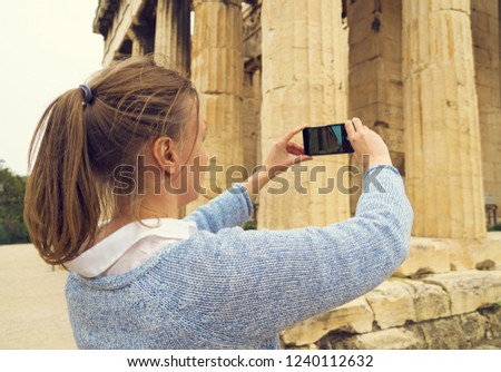 Woman photographing Temple of Hephaestus in Athens, Greece.