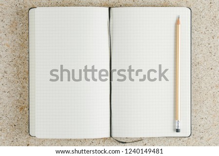 open school notebook with pencil on the table top view, notepad with blank page. flat lay of office concept