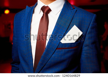 White business card in a jacket pocket