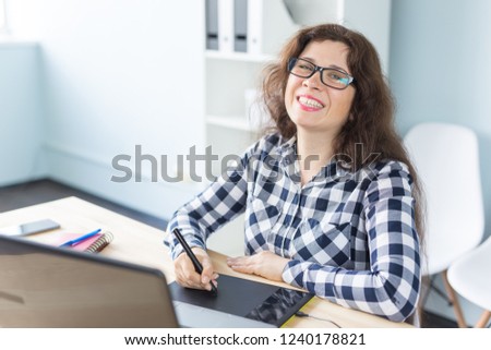 Photography, web design and graphic art concept - woman in glasses using mouse pan sketch device. Photo camera on the desk in coworking space