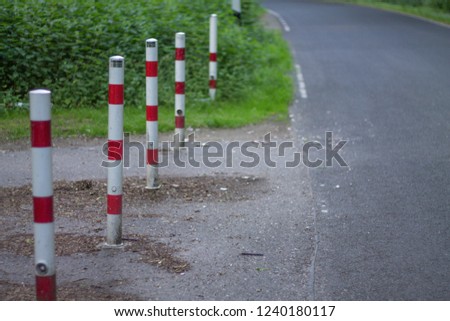 road signs entry stops red and white columns along the road
