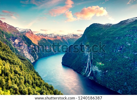 Splendid summer sunset of Sunnylvsfjorden fjord canyon, Geiranger village location, western Norway. Aerial evening view of famous Seven Sisters waterfalls. Beauty of nature concept background. Royalty-Free Stock Photo #1240186387