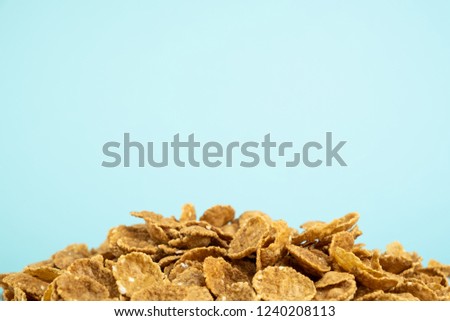 Heap of whole grain cereals with copy space. Healthy breakfast concept: close-up image of muesli on pale blue background