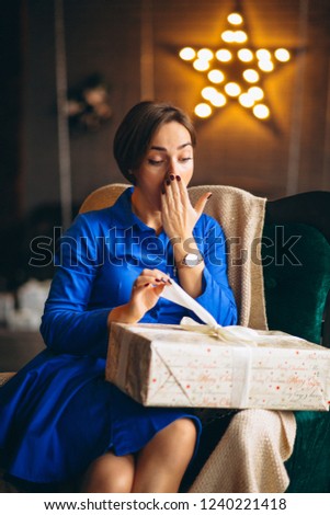 Woman unpacking presents by Christmas tree