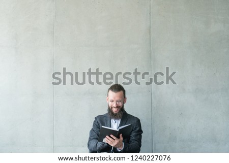 smiling man reading his day planner. information knowledge learning.