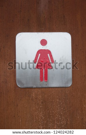 woman symbol in front of toilet wooden door