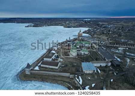 Aerial view of the fortress - a monastery with churches in the winter - spring time at dusk. Photo of a landscape from the drone