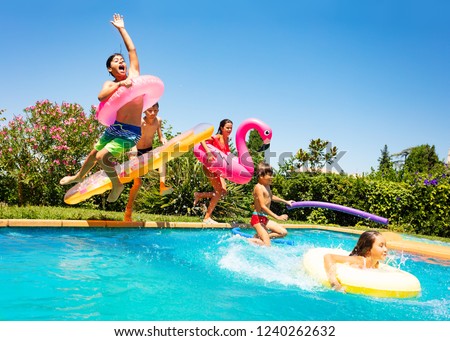 Happy friends jumping in pool on the vacations Royalty-Free Stock Photo #1240262632