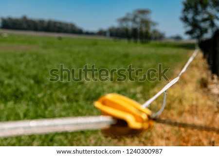 Close up of an electric fence to keep the animals inside the corral with shallow depth of field
