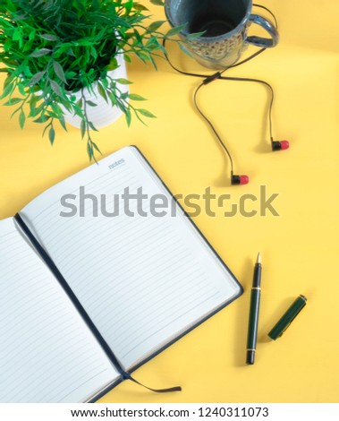 Workspace - creative flat photo of the desktop. Top view office desk with laptop, notebook and datebook against yellow background. Top view with copy space, photos.