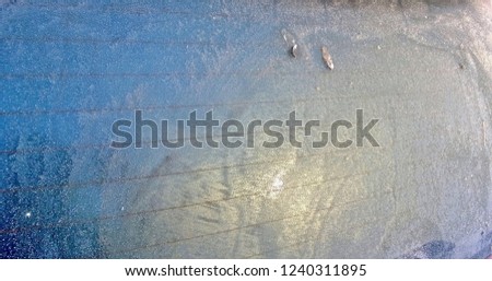 Texture and background of a frozen glass of a building or car on a clear winter day or morning. Snow. Frost.