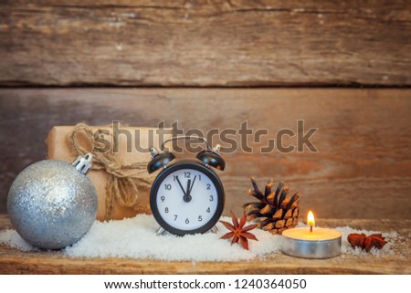 Christmas New Year composition winter objects gift box pine cones balls alarm clock on old shabby rustic wooden background. Xmas holiday december decoration copy space. Time for celebration