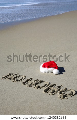 Santa Hat. Santa Claus hat on the beach with the word HO HO HO 
written in the sand. 
Room for text.
Words can be removed and replaced with your own. 

