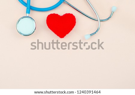 A Stethoscope and red heart on pink background.