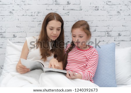 Relationship of mother and daughter concept. Mom and little girl using laptop computer to play game togethers in weekend at home.