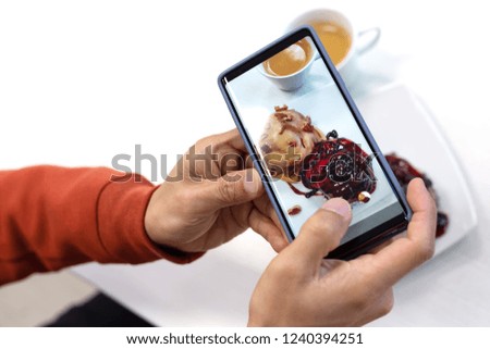 close up of young man using smart phone taking photo which take a picture food or bakery before eating, photography on white background