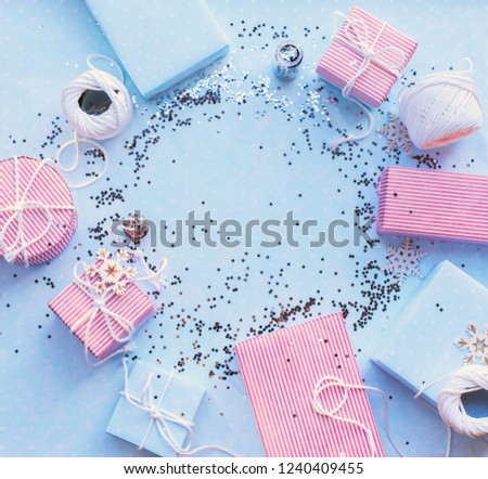 Christmas gifts. Festive pink box on blue background with glitter. Circl composition. Copy space Top view