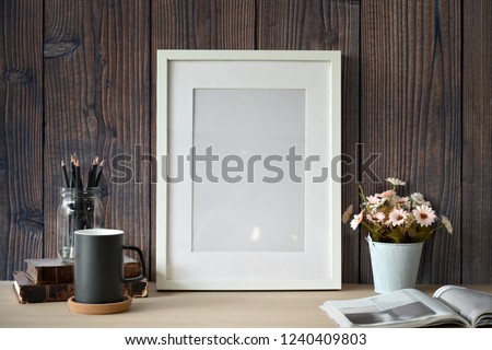 Mockup white poster with home office supplies over wooden wall.