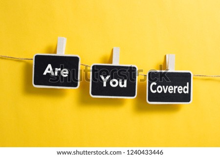 Small blackboards with Are You Covered concept is hanging on line.