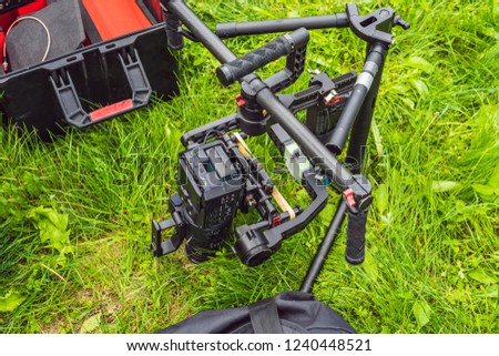 Cameraman setting up heavy duty professional 3-axis gimbal stabilizer for cinema camera