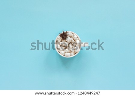 Winter composition. Cup of cocoa with marshmallows and anise star on blue background. Top view Flat lay Greeting card Copy space