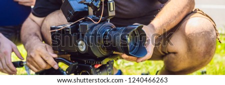 a professional cameraman prepares a camera and a tripod before shooting BANNER, long format