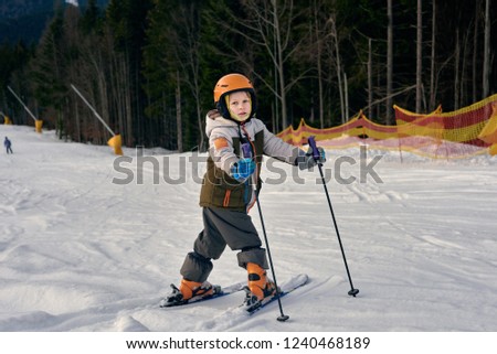 Teenager boy learning how to ski at winter mountains