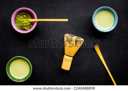 Brew matcha green tea. Matcha powder, ready matcha tea, whisk on black background top view