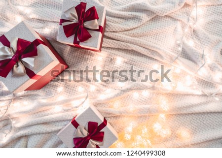 Wrapped gift with red ribbon on top of white cloth background