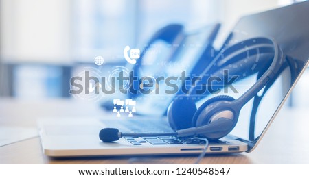 close up headphone of call center with telephone answer machine on table at operation room with virtual circle wheel business technology interface for telecommunication engineering concept Royalty-Free Stock Photo #1240548547