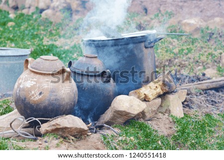 Rural clay pots outside with a lot of smoke.