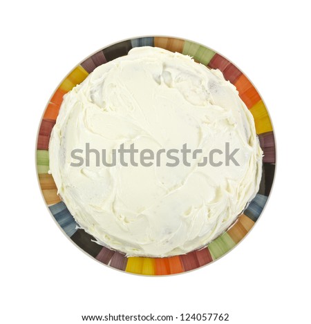 Looking down at a frosted layer cake on a colorful plate. Royalty-Free Stock Photo #124057762