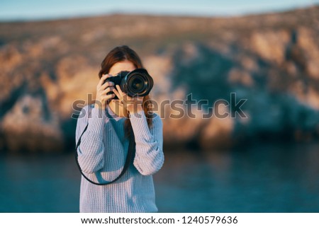 woman with a camera in hand in nature in the mountains                           