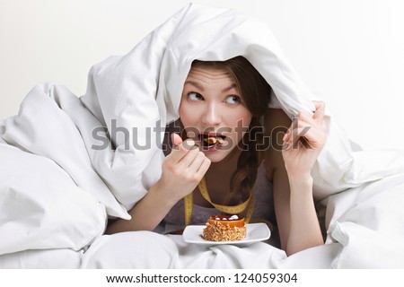 young beauty woman eating dessert under cover on white background Royalty-Free Stock Photo #124059304