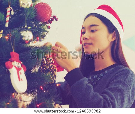 Asian woman decoration with Christmas tree at her home.