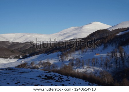 Panorama from the Stara Planina mountain ridge, Bulgaria. Snow peaks and hills with buildings. Panoramic.