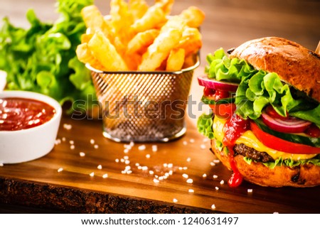 Tasty burger with chips served on cutting board