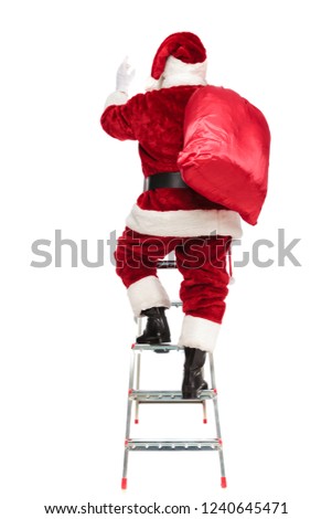 rear view of santa claus with sack on shoulder climbing on a ladder on white background, full length picture