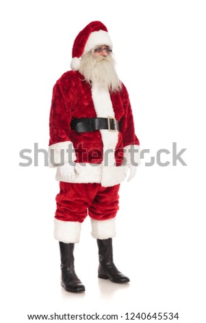 santa claus wearing glasses stands on white background and looks to side, full body picture